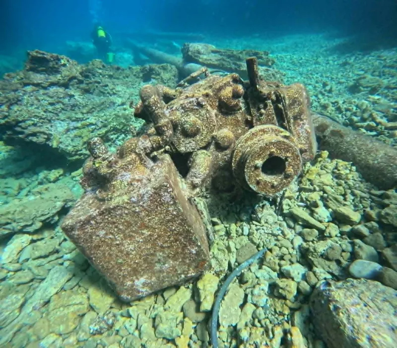 Epave rouillée au fond de la mer avec un plongeur en arrière-plan