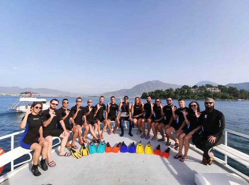 Groupe de plongeurs souriants sur le pont d'un bateau en mer