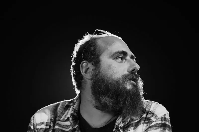 Portrait en noir et blanc d'un homme barbu regardant vers le haut