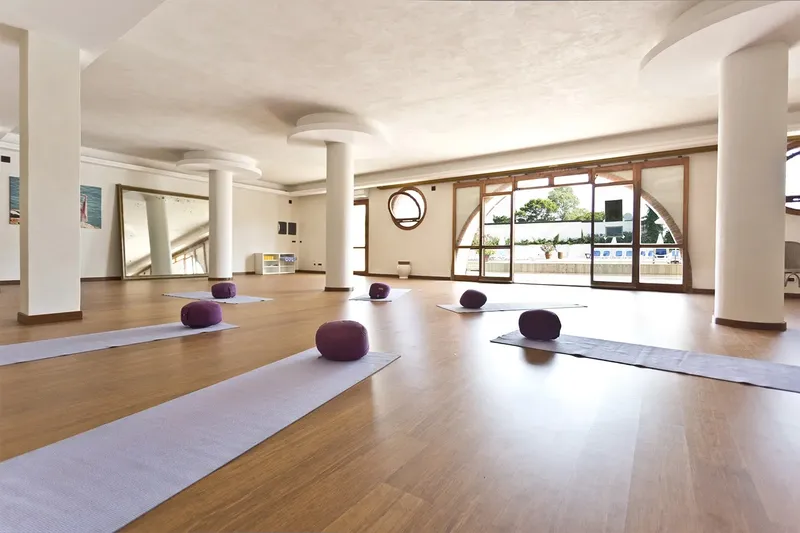 Salle lumineuse avec tapis de yoga et coussins violets disposés