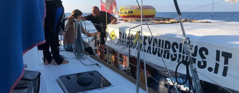 Personnes sur un bateau de plongée avec du texte incrusté visible