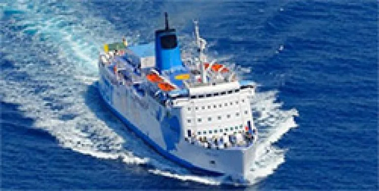 Grand ferry bleu et blanc navigue sur une mer agitée