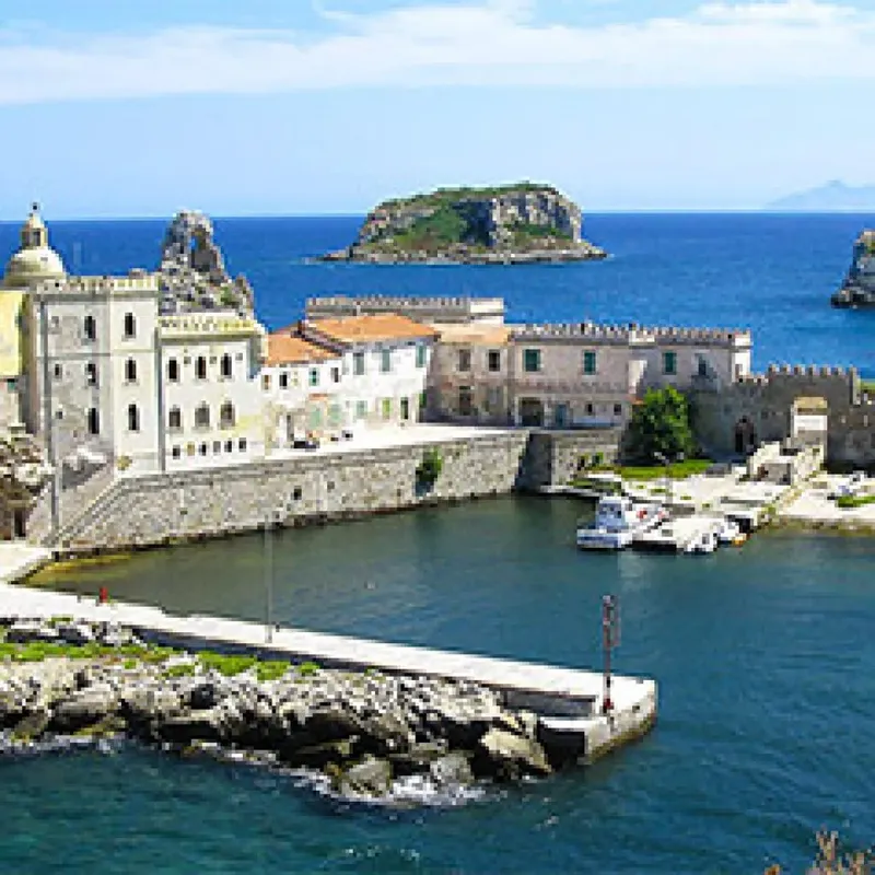 Port de ville avec bâtiments anciens, mer bleue et quelques bateaux amarrés