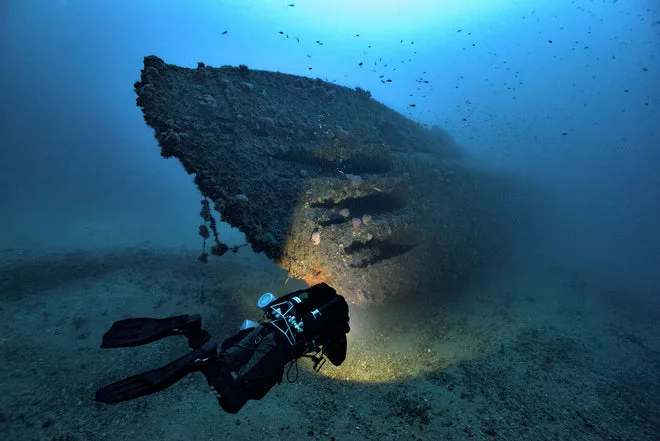 Plongeur explorant l'épave d'un navire sous-marin, lumière artificielle