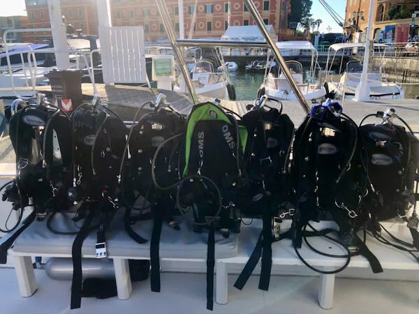 Rangée d'équipements de plongée complets sur un bateau en port