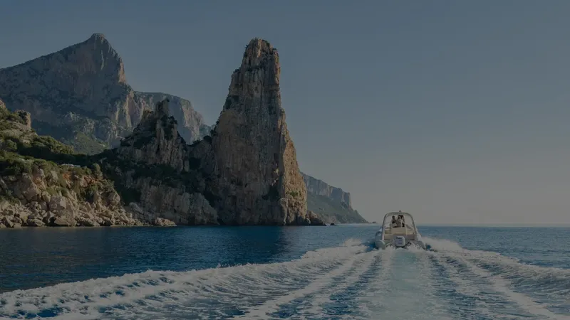 Bateau naviguant en mer avec des falaises rocheuses en arrière-plan