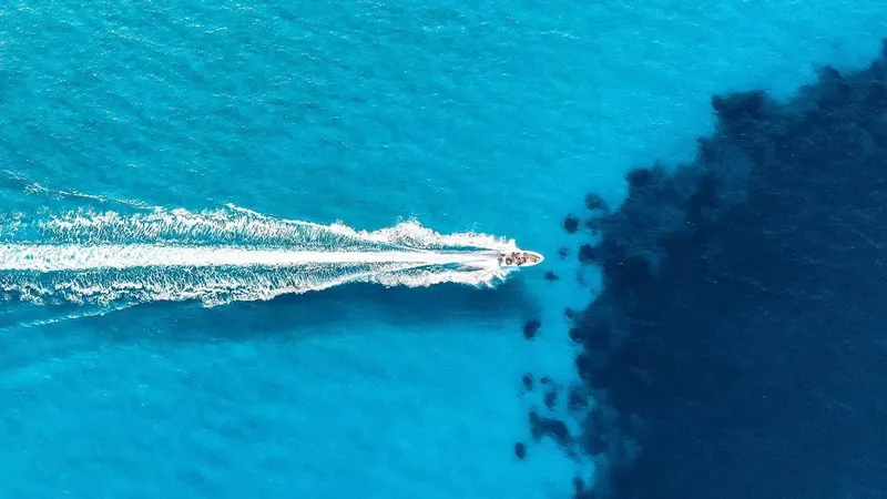 Vue aérienne d'un bateau rapide naviguant sur une mer turquoise claire