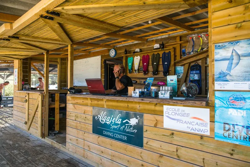 Comptoir d'accueil d'un centre de plongée avec du matériel et une personne