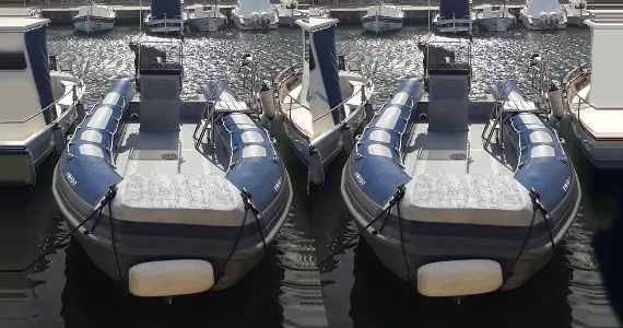 Plusieurs bateaux semi-rigides amarrés dans un port ensoleillé