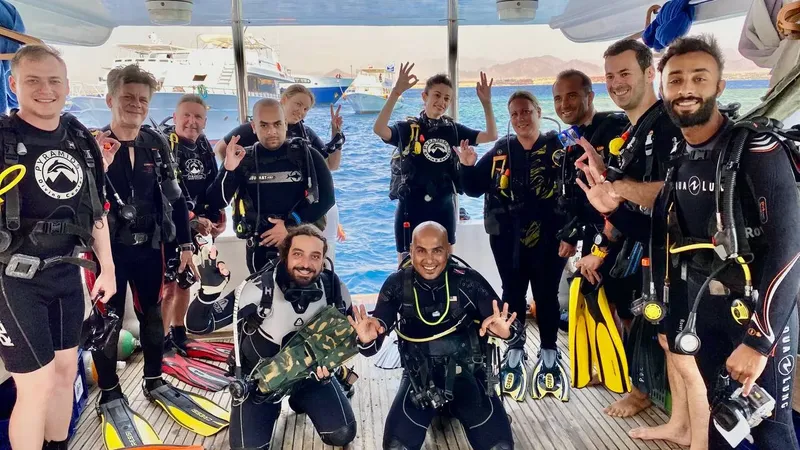 Groupe de plongeurs souriants sur le pont d'un bateau en mer