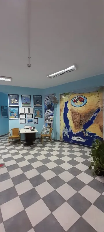 Salle d'attente avec des affiches de plongée et une grande carte marine