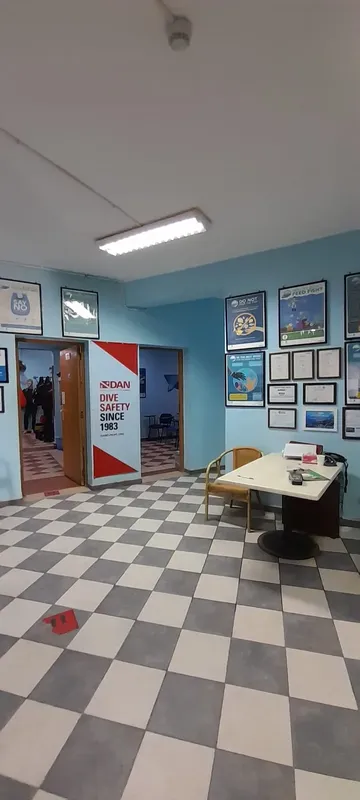 Intérieur d'un centre de plongée avec des affiches et des personnes
