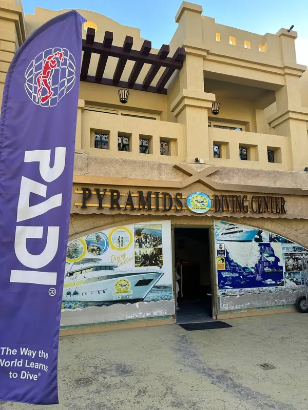 Façade d'un centre de plongée avec bateau et enseigne PADI visible