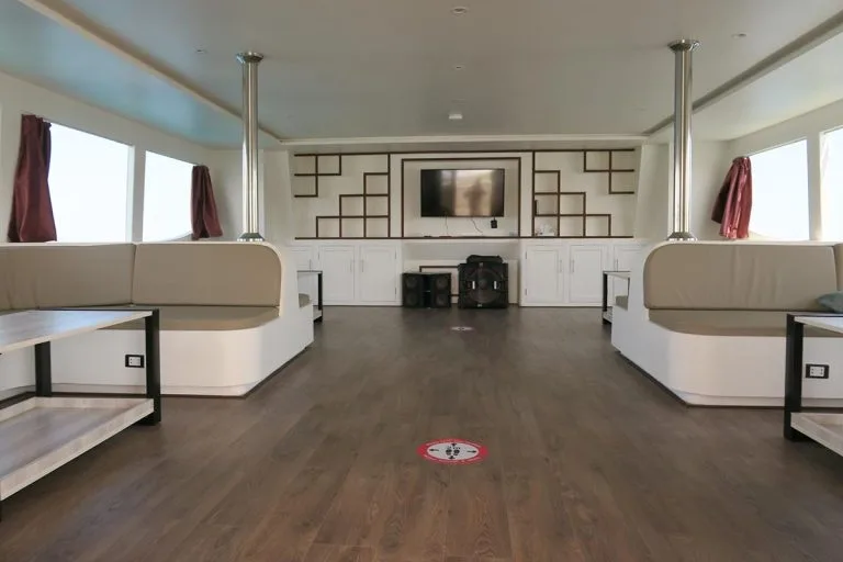 Intérieur d'un bateau de plongée avec banquettes, télévision et éclairage