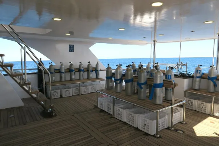 Bateau de plongée avec rangées de bouteilles bleues prêtes à l'utilisation