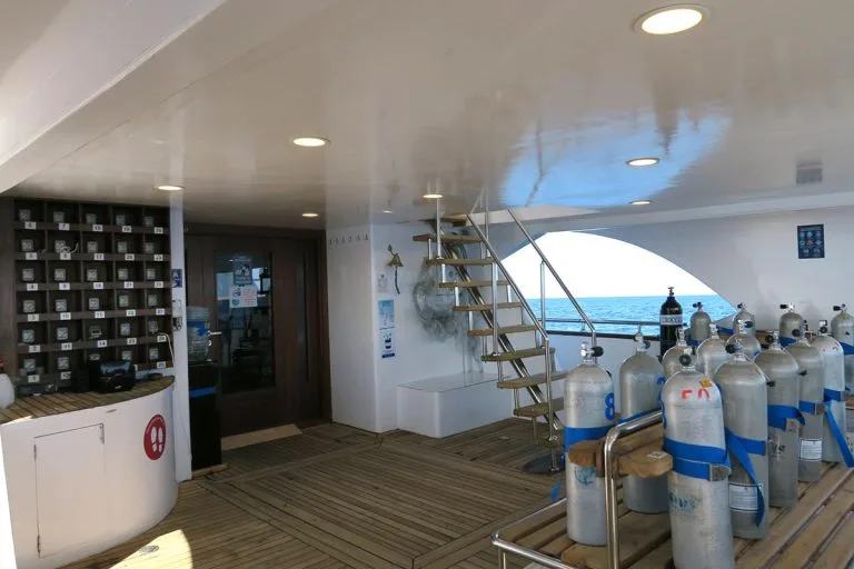Intérieur d'un bateau de plongée avec des bouteilles et un rangement