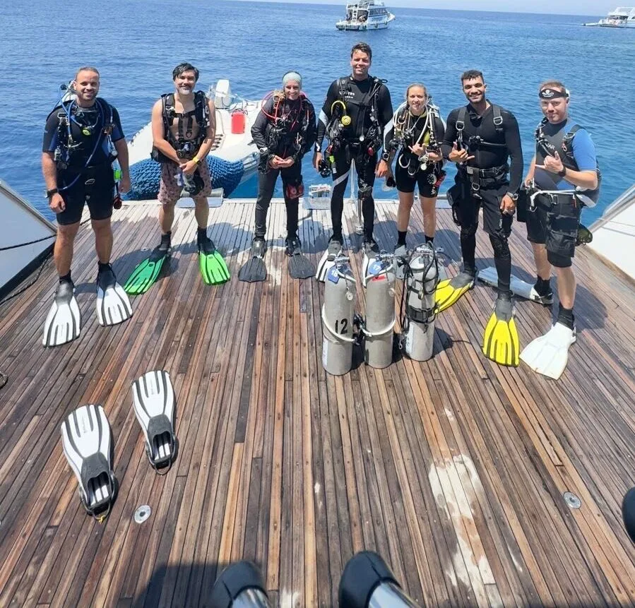 Groupe de plongeurs équipés sur le pont d'un bateau en mer