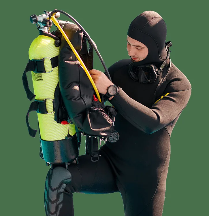 Plongeur préparant son équipement de plongée avec une combinaison intégrale
