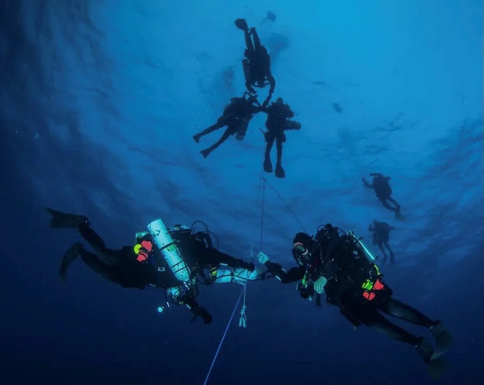 Plongeurs en formation, évoluant dans une eau bleue et profonde