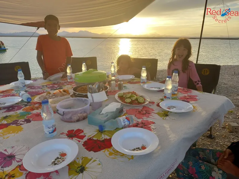 Repas convivial sur un bateau avec vue sur la mer au coucher du soleil