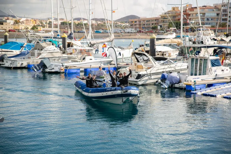 Groupe de personnes sur un bateau semi-rigide dans un port ensoleillé