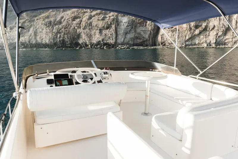 Intérieur d'un bateau de plaisance blanc naviguant en mer face à une côte rocheuse