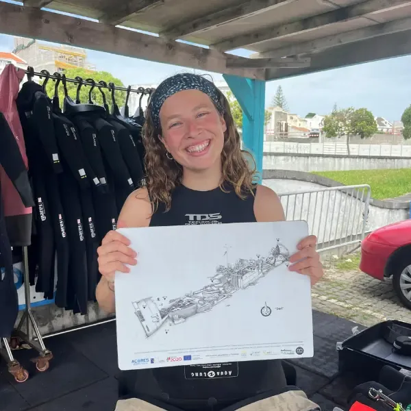 Jeune femme souriante tenant un dessin de bateau, combinaisons derrière