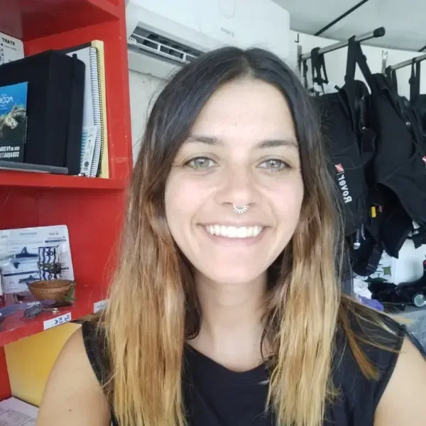 Portrait souriant d'une femme dans un centre de plongée avec équipement