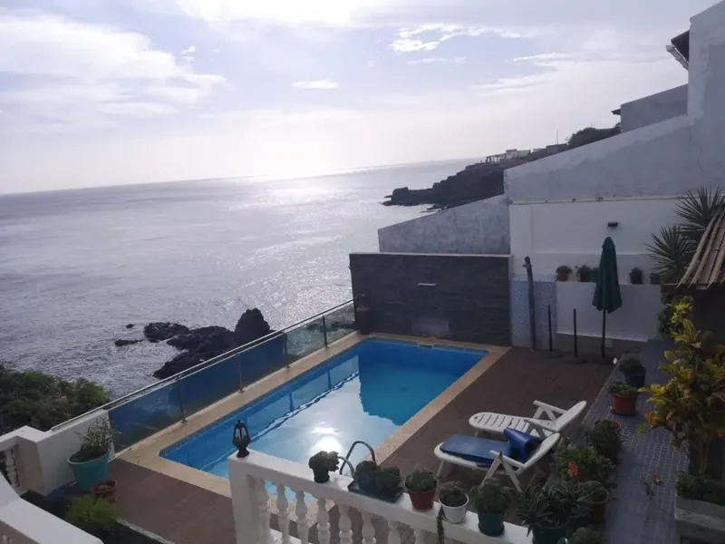 Piscine extérieure d'un centre avec vue sur la mer et rochers