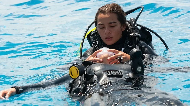 Plongeuse flottant à la surface, tenant un bébé en plastique blanc
