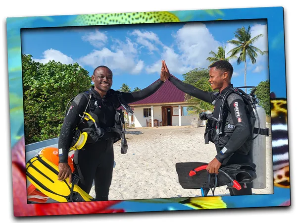 Deux plongeurs souriants se donnent un high-five sur une plage tropicale