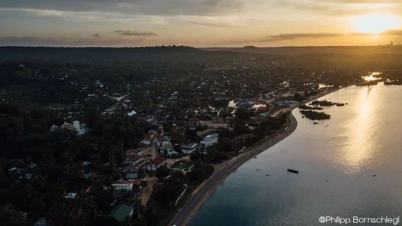 Vue aérienne d'une côte avec une ville et la mer au coucher du soleil