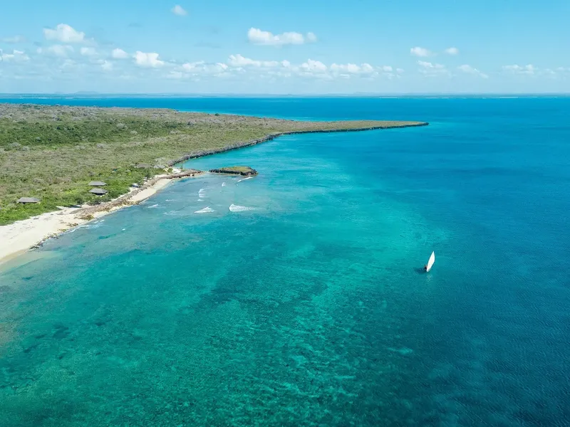 Vue aérienne d'une côte tropicale avec un voilier en mer