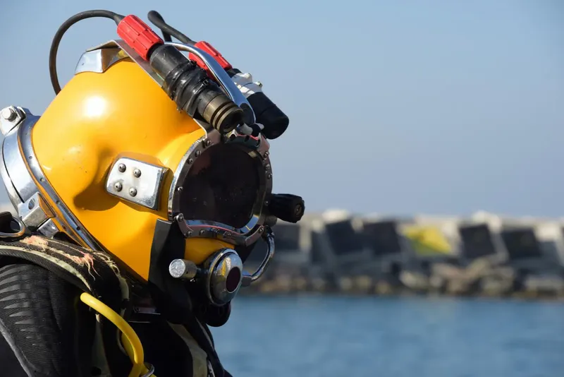 Plongeur portant un casque jaune classique, regardant vers la mer