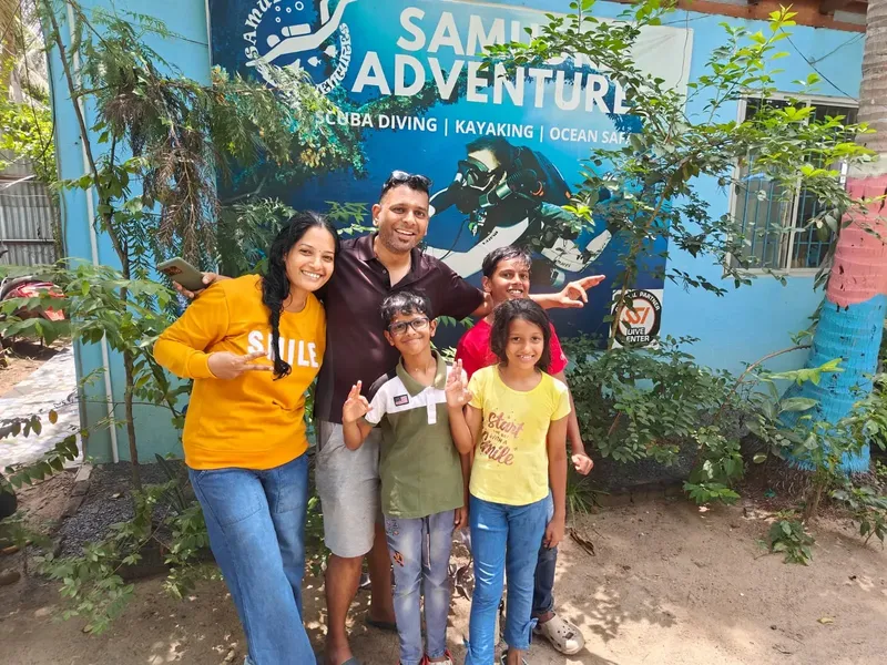 Famille souriante devant la devanture d'un centre de plongée colorée
