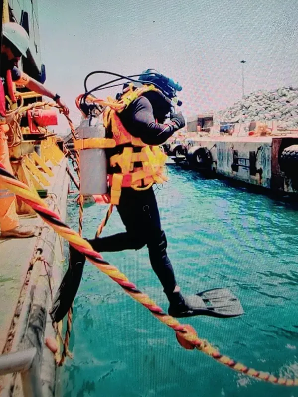 Plongeur s'apprête à entrer dans l'eau depuis un bateau de plongée