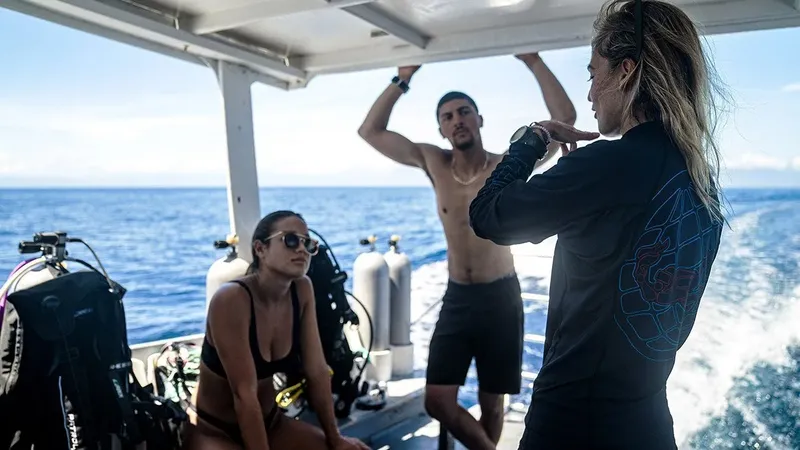 Deux plongeurs et un instructeur sur un bateau en mer