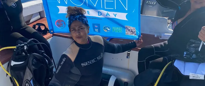 Plongeuses sur un bateau de plongée avec une bannière colorée