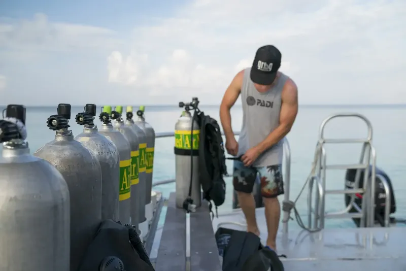 Plongeur préparant son équipement sur le pont d'un bateau en mer