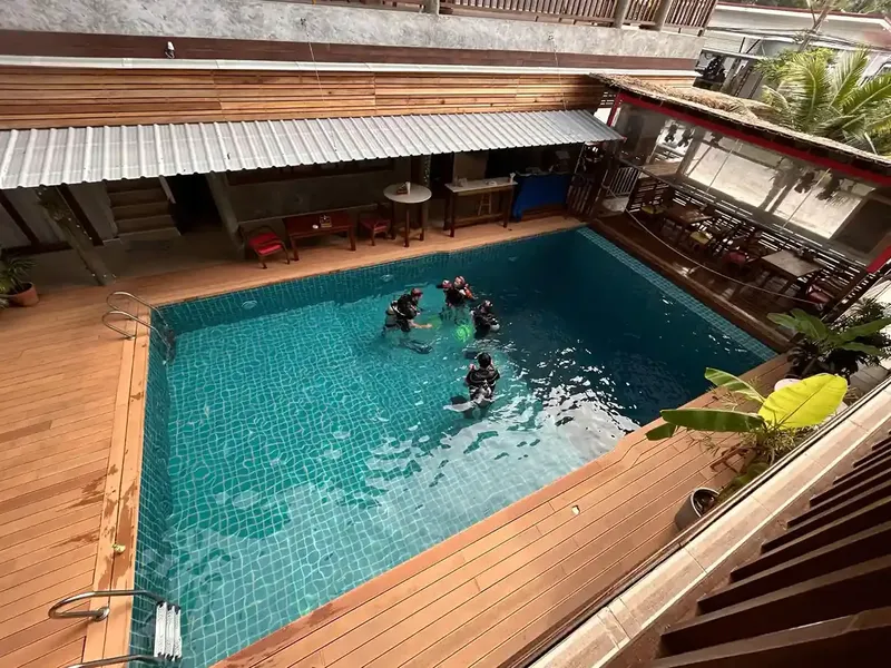 Des plongeurs s'entrainent dans une piscine avec du matériel complet