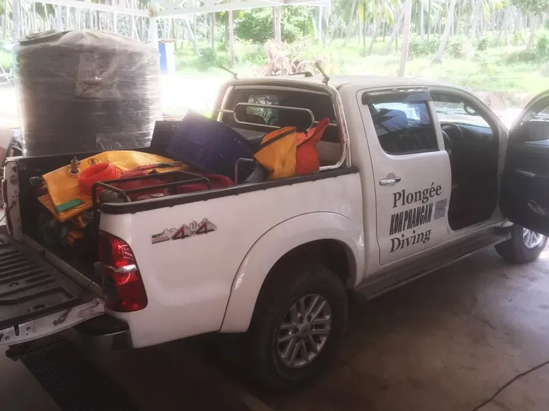 Pick-up blanc chargé de matériel de plongée et de gilets de sauvetage