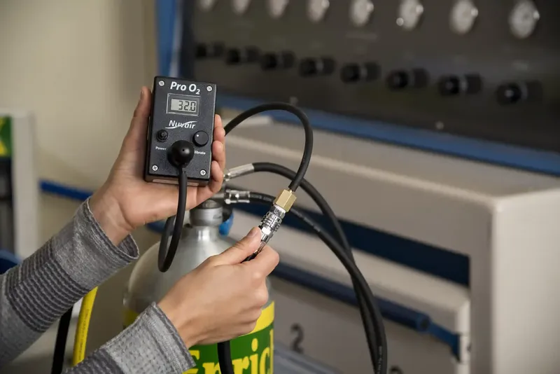 Mesure de l'oxygène dans une bouteille de plongée par un technicien