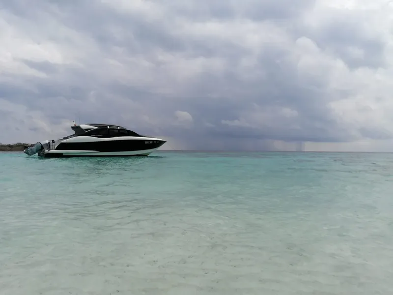 Bateau rapide amarré dans une eau turquoise sous un ciel nuageux