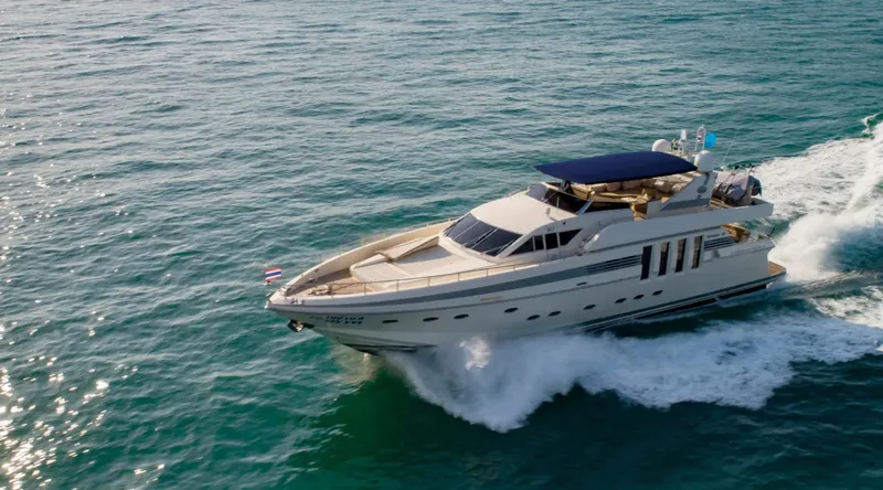 Grand yacht blanc et bleu naviguant sur une mer turquoise
