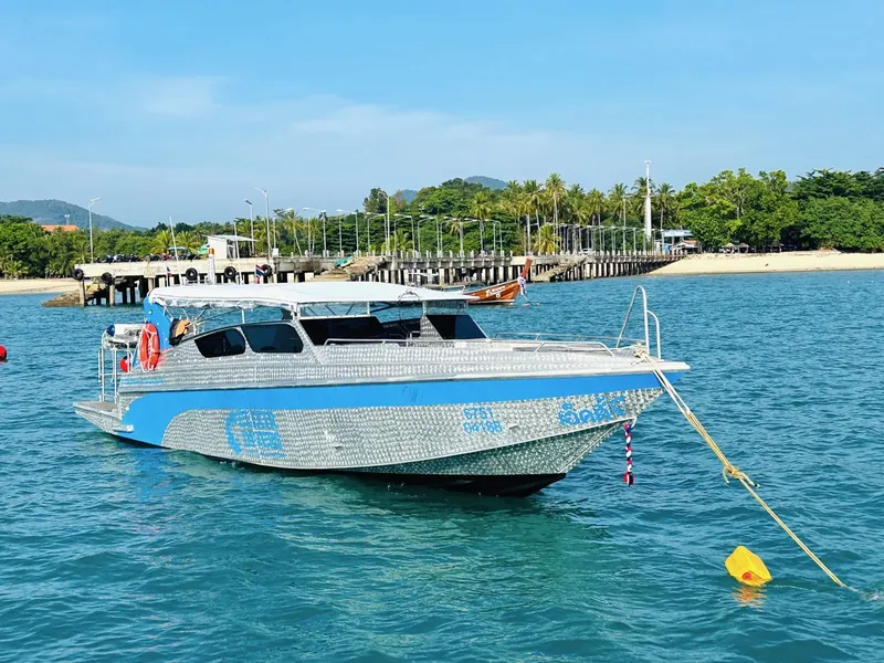 Bateau de plongée amarré dans une eau turquoise près d'une plage