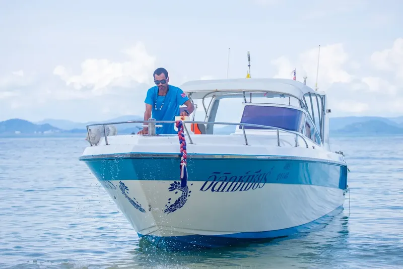 Homme sur un bateau de plaisance blanc et bleu en mer