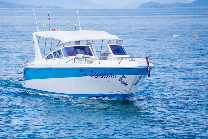 Bateau de plongée bleu et blanc naviguant sur une mer calme