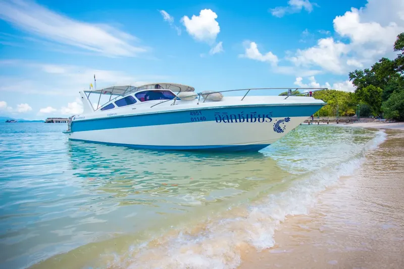 Bateau de plongée bleu et blanc échoué sur une plage ensoleillée
