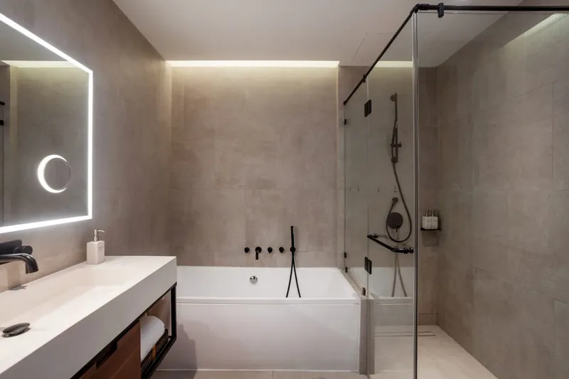Salle de bain moderne avec baignoire, douche à l'italienne et grand miroir