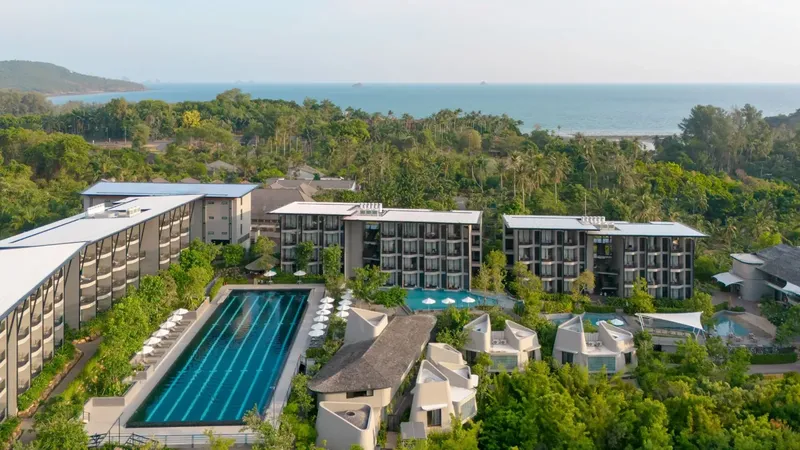 Vue aérienne d'un complexe hôtelier avec piscine et végétation luxuriante